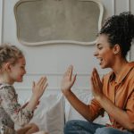 Adoption - Woman in Orange Long Sleeve Shirt Playing with Girl in Black and White Floral Long Sleeve Shirt