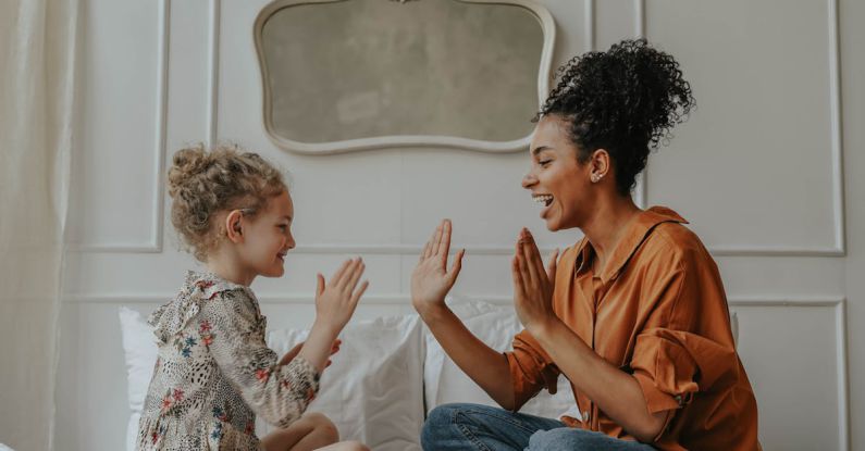 Adoption - Woman in Orange Long Sleeve Shirt Playing with Girl in Black and White Floral Long Sleeve Shirt