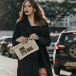 Cross-Platform - A woman in tights and a black coat is crossing the street