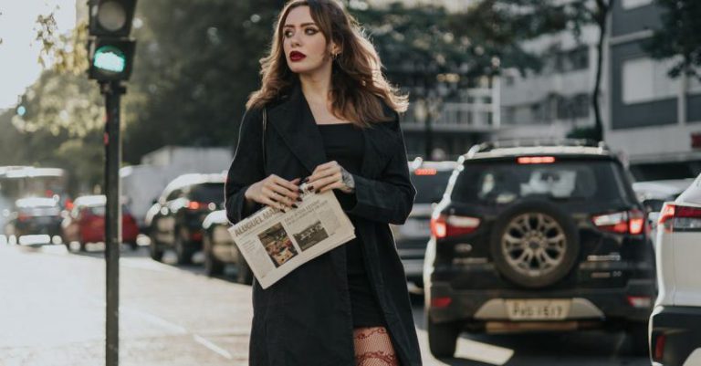 Cross-Platform - A woman in tights and a black coat is crossing the street