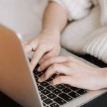 App Testing - Crop woman typing on laptop on bed