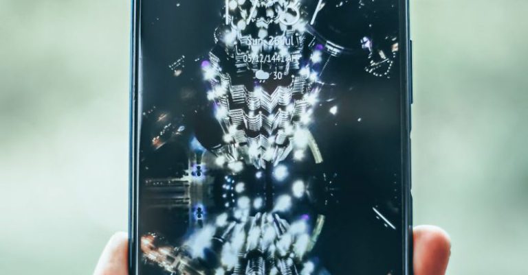 Web Apps - Crop person hand holding modern mobile phone with various apps and illuminated city on wallpaper