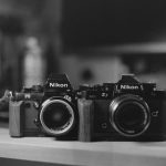 IoT Devices - Two cameras sitting on a desk in black and white