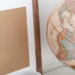 Open Source Projects - Vintage globe near blank frame and cup of tea placed on book in office